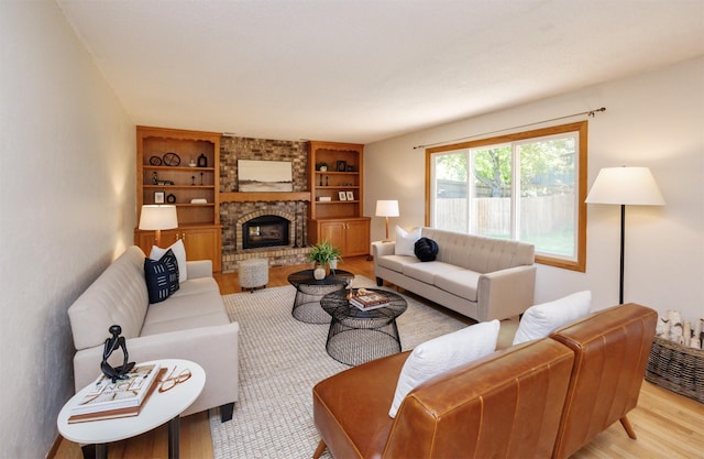 10476 Ricardo Rd, Clive, IA 50325 - living area featuring light wood-type flooring, built in shelves, and a brick fireplace