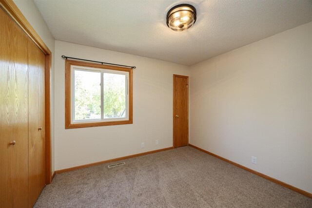 10476 Ricardo Rd, Clive, IA 50325 - unfurnished bedroom with a closet, carpet, and baseboards