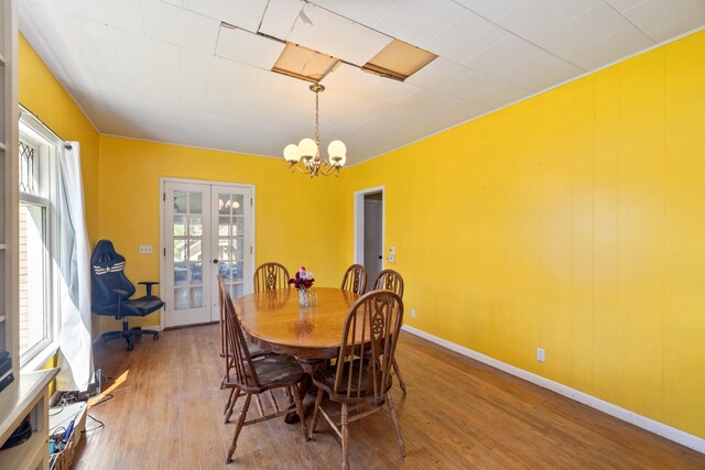 910 Washington St, Eldora, IA 50627 - dining room featuring wood finished floors, a chandelier, french doors, and baseboards