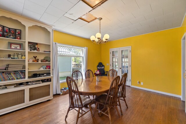 910 Washington St, Eldora, IA 50627 - dining space featuring a chandelier, hardwood / wood-style floors, french doors, and baseboards