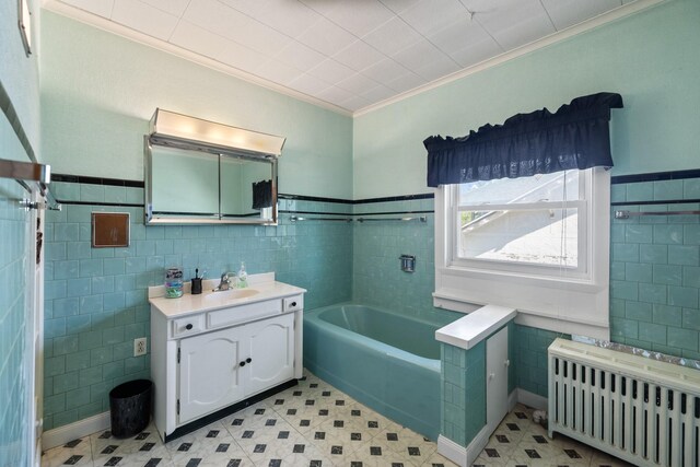 910 Washington St, Eldora, IA 50627 - bathroom featuring radiator, tile walls, ornamental molding, a bath, and vanity
