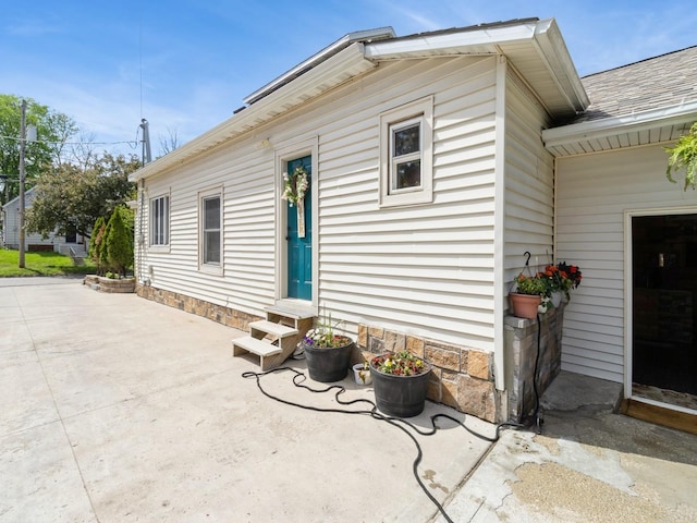 1273 E 18th St, Des Moines, IA 50316 - back of property featuring entry steps, a patio area, and a shingled roof