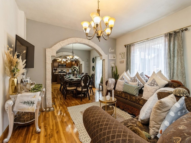 1273 E 18th St, Des Moines, IA 50316 - living area with arched walkways, a chandelier, and wood finished floors