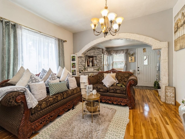 1273 E 18th St, Des Moines, IA 50316 - living area with arched walkways, a chandelier, and wood finished floors