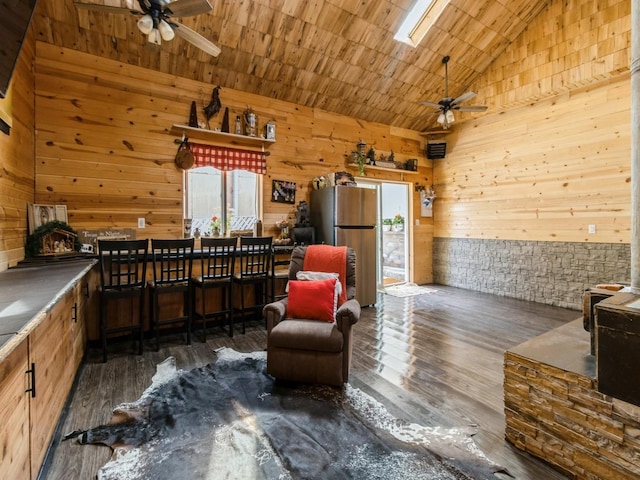 1273 E 18th St, Des Moines, IA 50316 - living area featuring a ceiling fan, wooden walls, hardwood / wood-style floors, and high vaulted ceiling