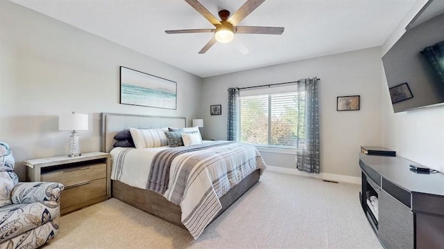 bedroom with light colored carpet, baseboards, and a ceiling fan
