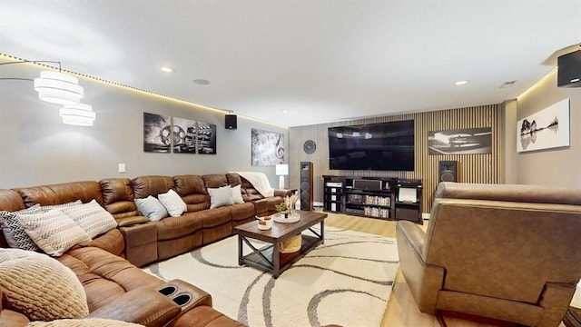 living area featuring light wood finished floors, recessed lighting, and an accent wall