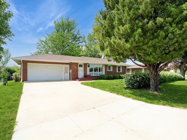 ranch-style home featuring a garage, concrete driveway, a front yard, and brick siding