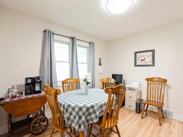 dining room with light wood-type flooring, an office area, and baseboards