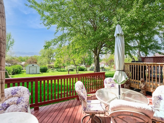 deck with a storage shed, an outbuilding, a yard, and outdoor dining area
