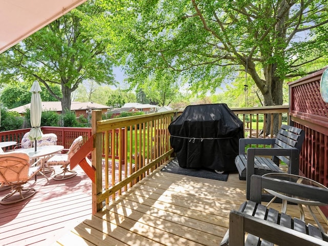 wooden terrace with outdoor dining space and grilling area