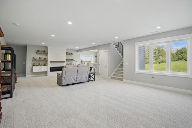 425 NW Woodmoor Dr, Waukee, IA 50263 - unfurnished living room with light colored carpet, recessed lighting, stairway, baseboards, and a fireplace
