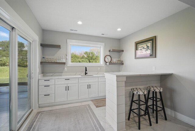 425 NW Woodmoor Dr, Waukee, IA 50263 - bar area with a sink, light marble finish flooring, baseboards, and recessed lighting
