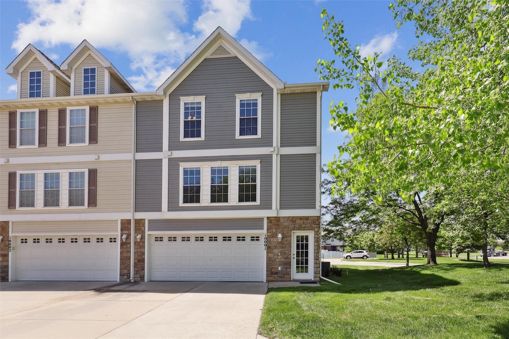 8302 Westown Pkwy Unit 10001, West Des Moines, IA 50266 - townhome / multi-family property featuring stone siding, driveway, a garage, and a front yard