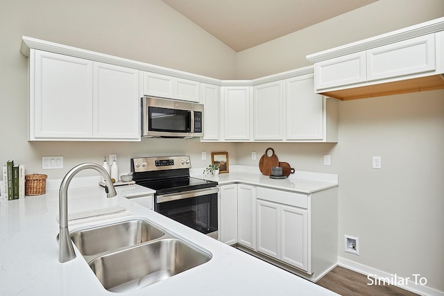 5560 165th St, Urbandale, IA 50323 - kitchen with appliances with stainless steel finishes, a sink, vaulted ceiling, white cabinets, and light countertops