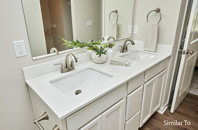 5560 165th St, Urbandale, IA 50323 - bathroom featuring double vanity and wood finished floors