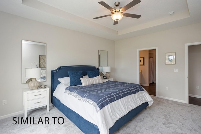 9410 Modena Ln, West Des Moines, IA 50266 - carpeted bedroom featuring a raised ceiling, baseboards, ensuite bathroom, and a ceiling fan