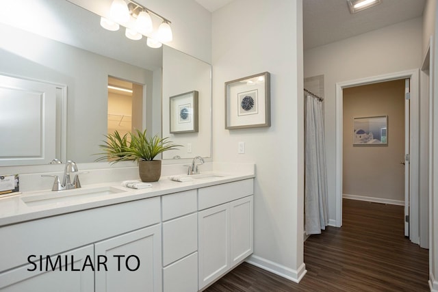 9410 Modena Ln, West Des Moines, IA 50266 - bathroom featuring double vanity, wood finished floors, baseboards, and a shower with curtain