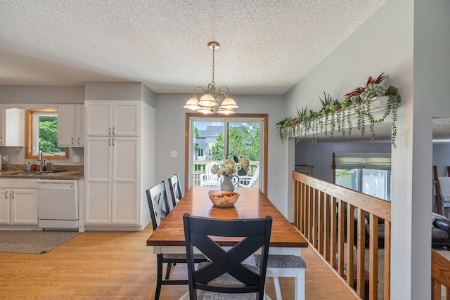 8123 Brookview Dr, Urbandale, IA 50322 - dining area with a textured ceiling, light wood-style flooring, and a chandelier