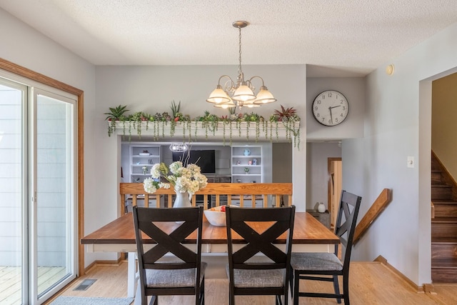 8123 Brookview Dr, Urbandale, IA 50322 - dining space featuring light wood-type flooring, a chandelier, plenty of natural light, and a textured ceiling