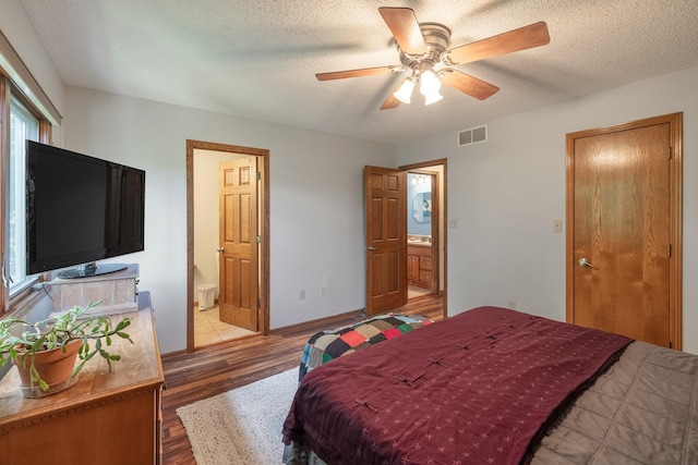 8123 Brookview Dr, Urbandale, IA 50322 - bedroom with wood finished floors, connected bathroom, a textured ceiling, and a ceiling fan