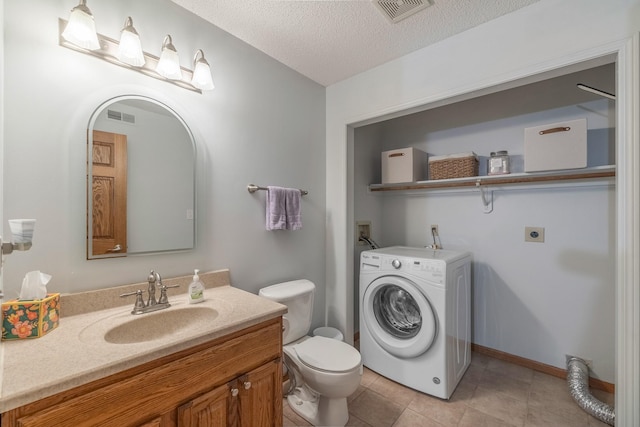 8123 Brookview Dr, Urbandale, IA 50322 - bathroom featuring washer / clothes dryer, vanity, a textured ceiling, and tile patterned floors
