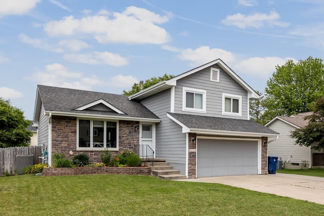 8123 Brookview Dr, Urbandale, IA 50322 - tri-level home with a shingled roof, stone siding, an attached garage, and driveway