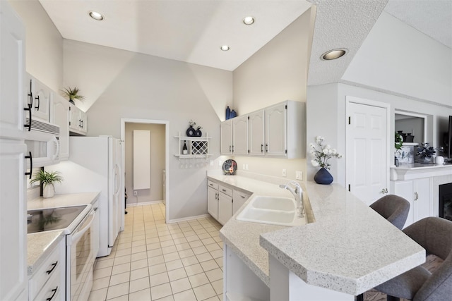 4400 Ep True Pkwy Unit 51, West Des Moines, IA 50265 - kitchen featuring white appliances, a sink, a peninsula, a breakfast bar area, and light countertops