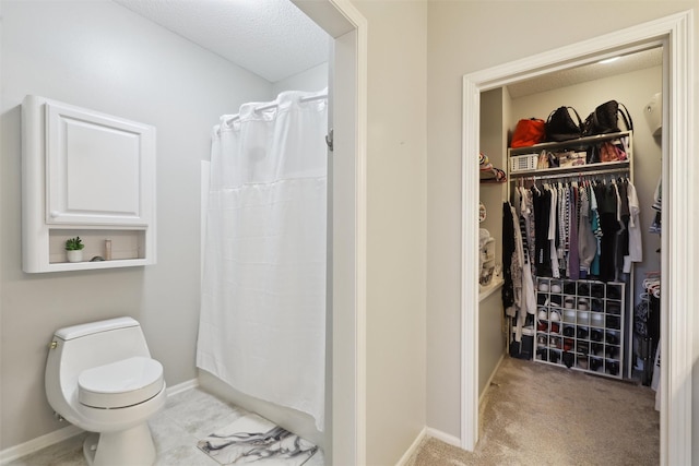 4400 Ep True Pkwy Unit 51, West Des Moines, IA 50265 - full bath with toilet, a shower with shower curtain, a walk in closet, baseboards, and a textured ceiling
