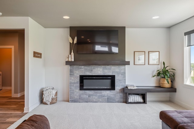 living room featuring baseboards, a tile fireplace, plenty of natural light, recessed lighting, and carpet flooring