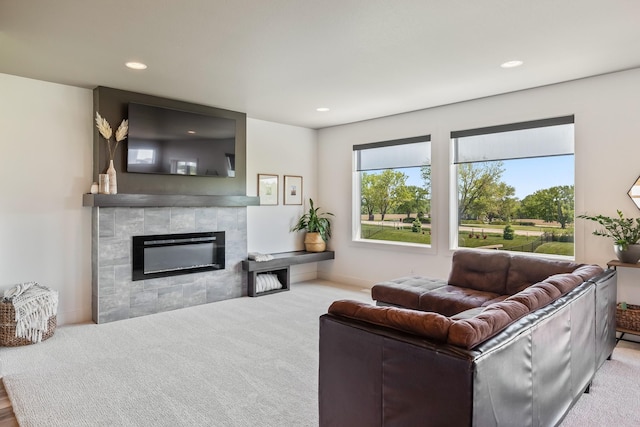 living area featuring a tile fireplace, recessed lighting, and carpet