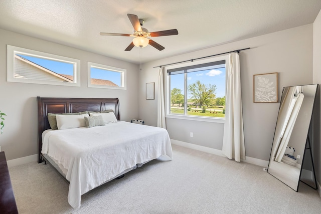bedroom with baseboards, light carpet, and a ceiling fan