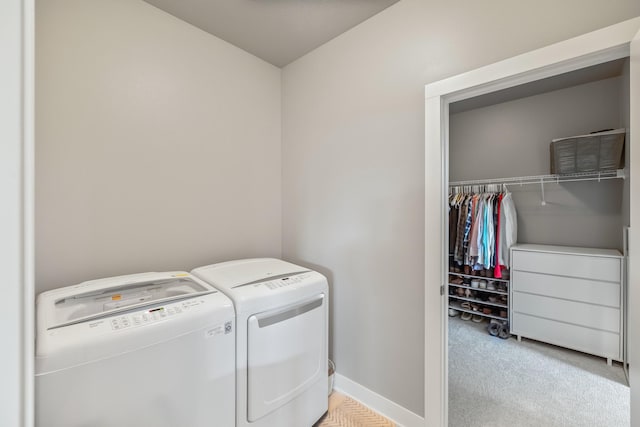 laundry area with washer and dryer, light colored carpet, and baseboards