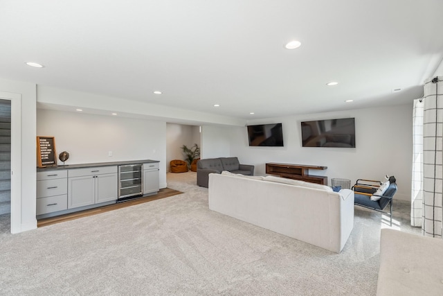 carpeted living room with beverage cooler, a bar, and recessed lighting