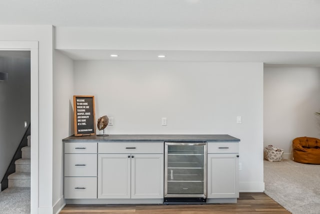 indoor dry bar featuring beverage cooler, light wood finished floors, recessed lighting, baseboards, and stairs