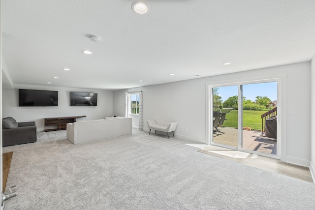 carpeted living area with baseboards and recessed lighting