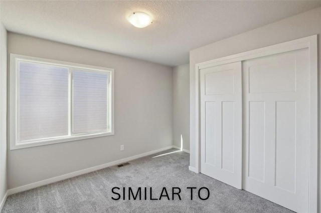 928 Spruce Ave, Norwalk, IA 50211 - unfurnished bedroom with carpet, a closet, and a textured ceiling