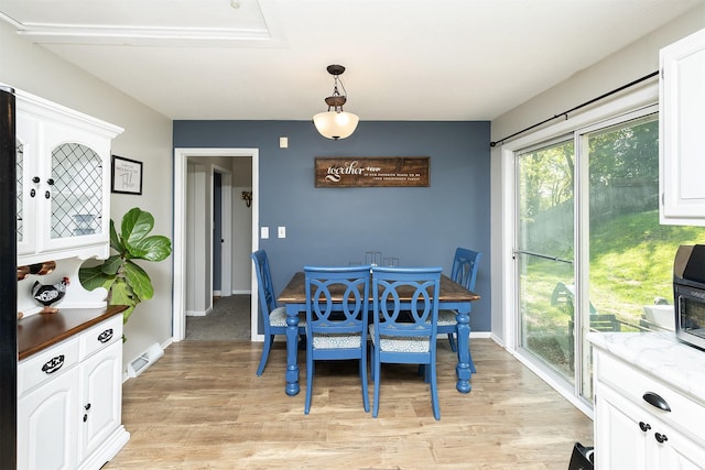 dining space featuring light wood finished floors and baseboards