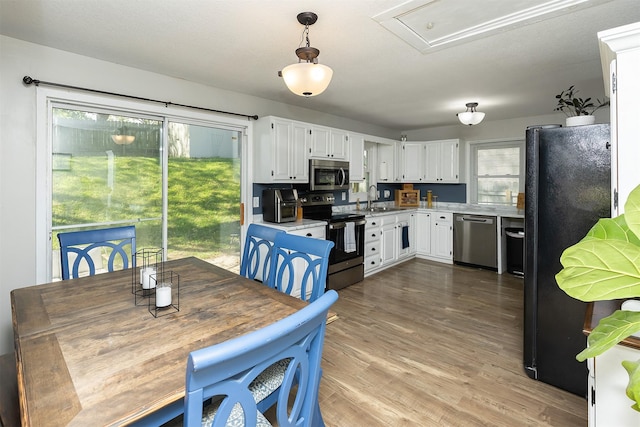 dining space featuring wood finished floors and attic access