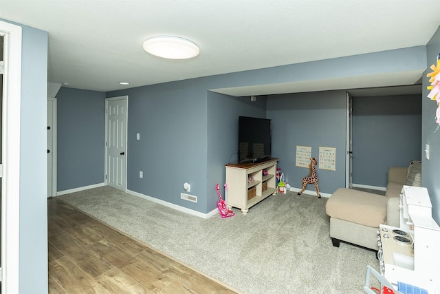 living room with baseboards, wood finished floors, and carpet floors