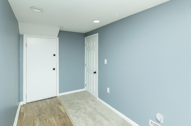 spare room featuring baseboards and light wood finished floors