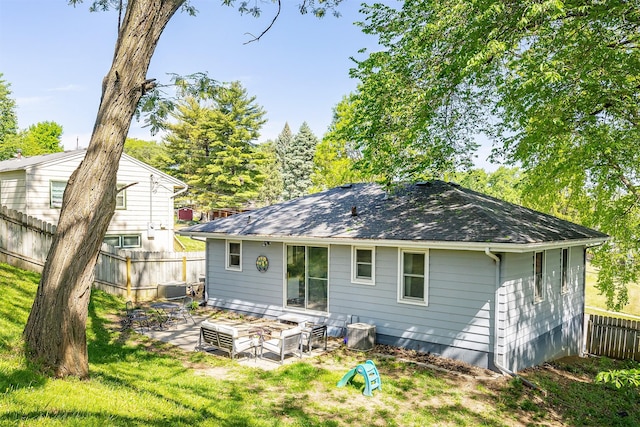 rear view of property featuring a patio, central AC, and roof with shingles