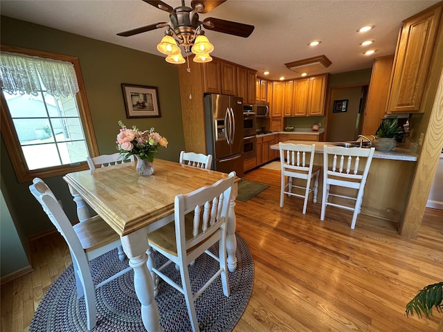 711 E Madison St, Winterset, IA 50273 - dining space with light wood finished floors, a ceiling fan, and recessed lighting