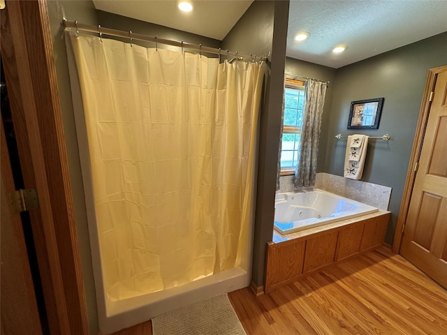 711 E Madison St, Winterset, IA 50273 - full bathroom featuring wood finished floors, a tub with jets, and a shower with shower curtain