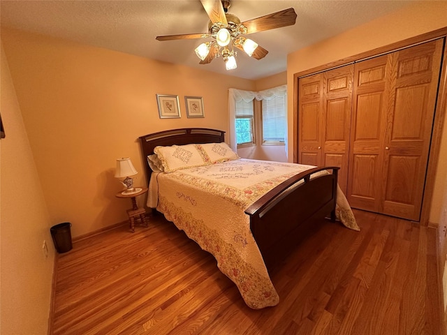 711 E Madison St, Winterset, IA 50273 - bedroom with wood finished floors, a closet, ceiling fan, a textured ceiling, and baseboards