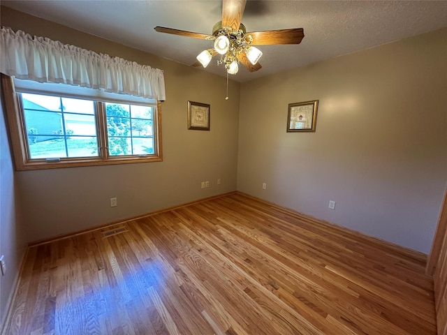 711 E Madison St, Winterset, IA 50273 - spare room with light wood-style flooring, ceiling fan, and baseboards