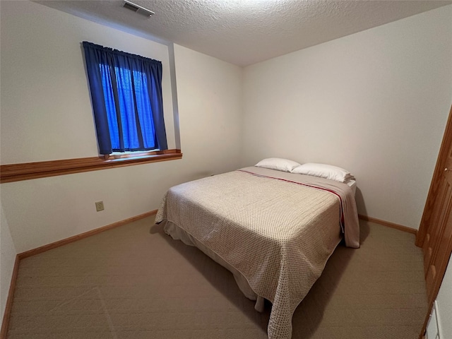 711 E Madison St, Winterset, IA 50273 - carpeted bedroom featuring baseboards and a textured ceiling