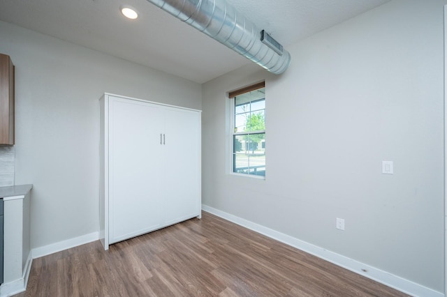 unfurnished bedroom featuring wood finished floors and baseboards