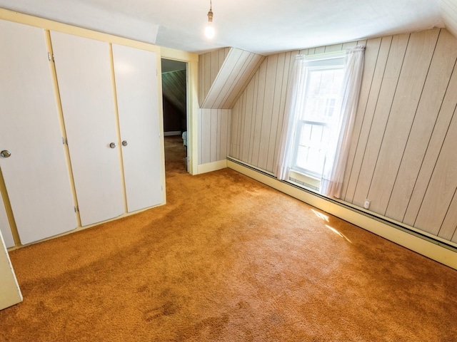 820 Main St, Norwalk, IA 50211 - additional living space featuring carpet, baseboard heating, vaulted ceiling, and wooden walls