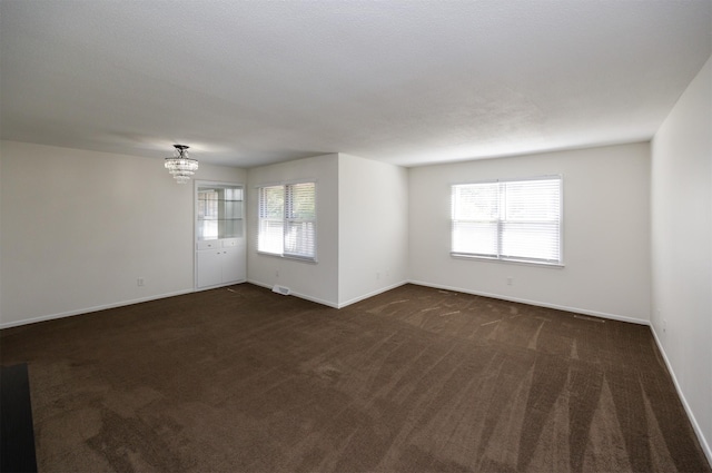 1667 NW 93rd Ct, Clive, IA 50325 - unfurnished room with a chandelier, dark carpet, and baseboards